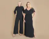 Two women in elegant black evening attire, a wide-leg jumpsuit and a flowing gown, ready for a formal event.