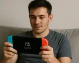 Mężczyzna gra na konsoli Nintendo Switch, szukając najlepszych gier na Switch.