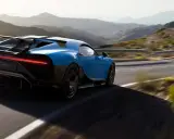 Blauer Bugatti Chiron Pur Sport rast auf einer kurvigen Bergstraße.