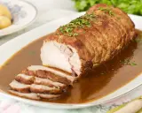Lomo de cerdo al horno en papel aluminio, jugoso y tierno, bañado en salsa y espolvoreado con perejil.