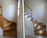 Avant/après : modernisation d'un escalier bois. L'ancien bois brut laisse place à un design épuré avec garde-corps moderne et marches lumineuses.