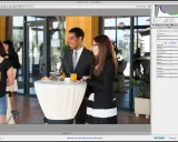 Un hombre y una mujer conversan junto a una mesa cubierta con un mantel blanco. El archivo es un formato raw, listo para editar.