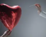 Czerwone serce-balon trzymane w dłoni, druga dłoń z igłą zbliża się do niego. Symbolizuje współżycie w trakcie rozwodu, które jest na skraju pęknięcia.