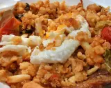 Plato de migas con huevo frito, pimientos y tomate, un delicioso ejemplo de comida típica de Jaén.
