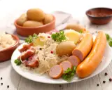 Assiette de choucroute garnie, pommes de terre et saucisses, un classique de la gastronomie alsace.
