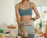 Frau bereitet einen gesunden Smoothie zu. Sie fragt sich, ob Proteinpulver beim Abnehmen hilft.