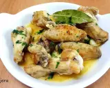 Alitas de pollo al ajillo, doradas y jugosas, servidas en una salsa con ajo y perejil fresco. ¡Un manjar irresistible!