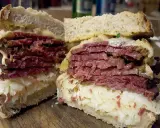 Pyszny reuben sandwich z grubymi plastrami wołowiny, kiszoną kapustą i serem, podany na chlebie żytnim.