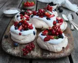 Små pavlovakakor med vispgrädde och färska bär som jordgubbar, hallon, blåbär och vinbär. En härlig sommardessert!
