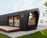 Modernes, dunkles Cabin House mit Holzterrasse und großem Fenster. Ein stilvolles Zuhause für minimalistisches Wohnen.