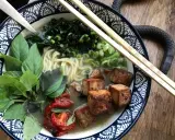 En skål med vegetarisk ramen med nudlar, tofu, grönsaker och basilika.