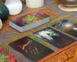Tarot dzienny ryby: karty z mistycznymi obrazami, kryształ, kule i ozdobny obrus tworzą atmosferę wróżenia.