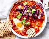 Herzhaftes Gericht mit pochierten Eiern in Tomatensoße, Bohnen, Avocado und Rotkohl. Perfekt für gesunde Rezepte Abendessen. Dazu geröstetes Fladenbrot.