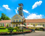 Wieliczka atrakcje: Szyb Daniłowicza, żółte budynki kopalni, zielony ogród i ludzie odpoczywający pod namiotami.