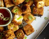 Krispiga, gyllene tofu-bitar serveras med en söt chilisås. Ett perfekt tofu recept för en snabb och god måltid.