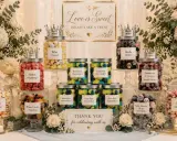 Mesa de dulces para bodas, con frascos de chuches como preparar bolsas de chuches originales. Flores y velas decoran.