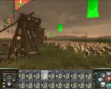 Bitwa w grze strategicznej, przypominającej gry podobne do Total War. Ogromna armia w starożytnych strojach, machiny oblężnicze i flagi na tle pochmurnego nieba.