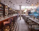 Elegant restaurang med bardisk, sammetsstolar och vackra lampor. Perfekt för en trevlig kväll, som många **sorellina recensioner** vittnar om.