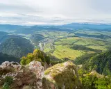 Widok z góry na dolinę z rzeką i miasteczkiem, w oddali majaczą Tatry. Trzy Korony w pełnej krasie.