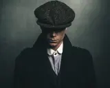 Mężczyzna w kaszkiecie i płaszczu, uosabiający styl lat 20. moda męska polska.