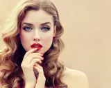 Glamouröse Frau mit voluminösen, welligen Haaren und roten Lippen. So gelingen Hollywood Waves selber machen!