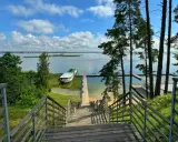 Drewniane schody prowadzą do jeziora, gdzie cumuje statek. Idealne miejsce, by zapytać: gdzie na Mazury?