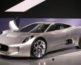 Silberner Jaguar C-X75 mit Flügeltür, der auf einer Messe ausgestellt wird.