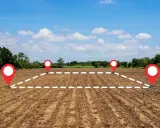 Wyznaczone punkty i przerywana linia na zaoranym polu symbolizują przekształcenie działki rolnej na budowlaną.