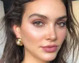 Maquillaje invitada boda ojos marrones. Piel luminosa, labios rosados y pendientes dorados.