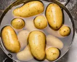 Des pommes de terre nouvelles dans une casserole d'eau, prêtes pour une délicieuse recette de pomme de terre.