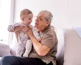 Abuela sonríe a su nieto varón, compartiendo un momento tierno. Ella tiene frases de amor para él.