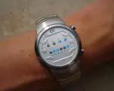 Zegarek na rękę z cyfrowym wyświetlaczem binarnym i niebieskimi diodami LED.