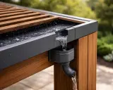 Système d'évacuation eau de pluie pergola en action, l'eau ruisselle sur le toit en bois et métal vers la gouttière.