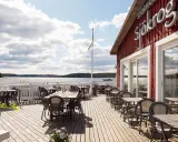 Välkommen till en restaurang vid vattnet i Stockholm! Njut av utsikten över skärgården från en av de många borden på trädäcket.