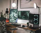 Escritorio moderno con doble monitor, PC con luces RGB, altavoces y plantas. Ideas para tu habitación gamer.
