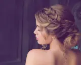 Elegante Frisur für Hochzeitsgäste: Ein kunstvoller Dutt mit geflochtenen Akzenten und zarten Locken.