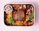 En saftig vildsvinsstek i ugn med rostade rotfrukter och en skål med lingonchutney.