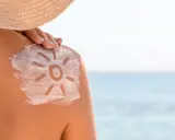 Soleil dessiné sur l'épaule avec de la crème solaire. Attention au danger de la crème solaire tous les jours.