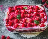 Ein köstliches Tiramisu mit frischen Himbeeren und Minze, das zeigt, wie man Tiramisu dekorativ anrichten kann.