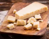 Parmesan-Stücke auf Holzbrett. So einfach kann parmesan einfrieren sein, um den Geschmack zu bewahren.