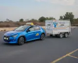 Coche azul de autoescuela con remolque, preparándose para el examen del carnet B96.