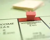 Une petite maison rouge sur le plateau Monopoly, près de Whitechapel Road. Le jeu simule le transfert de prêt.