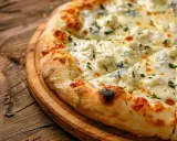 Pyszna pizza quattro formaggi z rozpływającym się serem i ziołami, podana na drewnianej desce.
