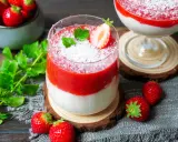 Zwei leckere eistörtchen mit Erdbeeren und Kokosraspeln, garniert mit Minze und frischen Erdbeeren.