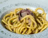 Un piatto di spaghetti con acciughe e prezzemolo, un'ottima idea per scoprire cosa mangiare a Padova.