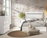 Dormitorio moderno con cabecero de cama en blanco veteado, papel tapiz botánico y cómoda a juego. Un diseño que evoca la calma del feng shui.