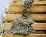 Vertido de hormigón fresco en el armado de una escalera de madera.