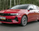 Czerwony Opel Astra Turbo pędzi leśną drogą.