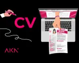 Ręka pisze CV na laptopie. Proces tworzenia idealnego CV.