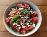 En uppfriskande sallad med tärnad vattenmelon, smulad fetaost och färsk basilika, ringlad med balsamvinäger.